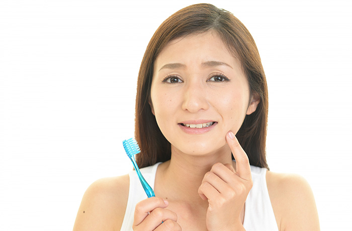 歯磨きを持つ女性の写真