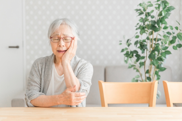歯が痛い高齢者女性 