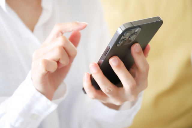 スマホを操作する手元 