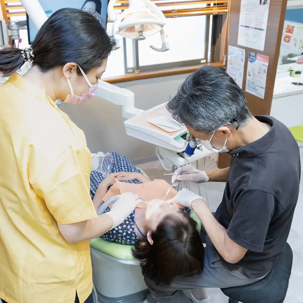 永沢デンタルクリニック院長がスタッフと一緒に治療を行っている
