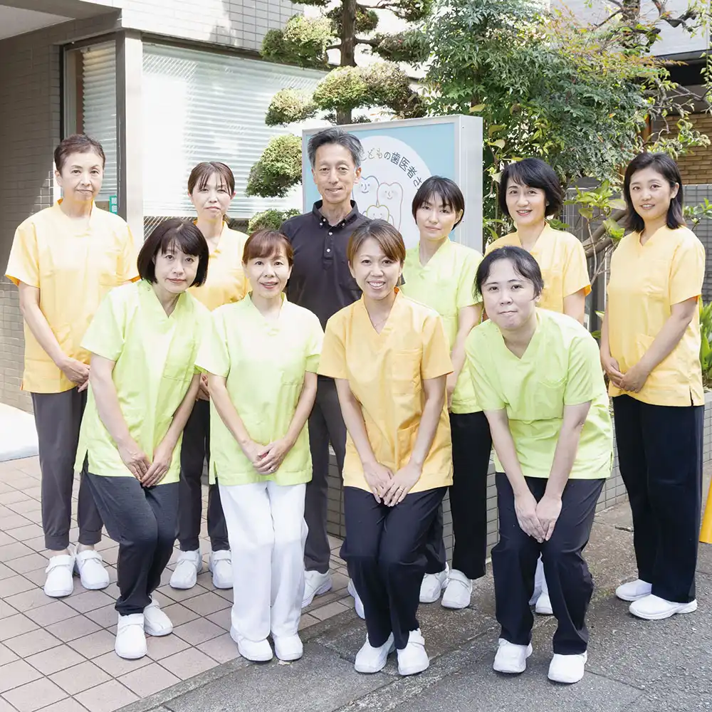 永沢デンタルクリニック院長とスタッフが医院外で並んでいる