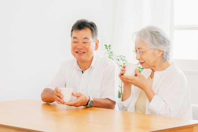 テーブルに座る高齢者夫婦(お茶)