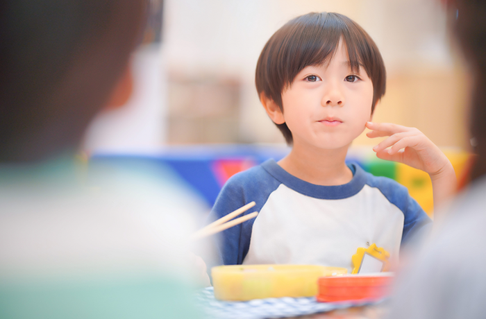 お弁当を頬張って食べる男の子