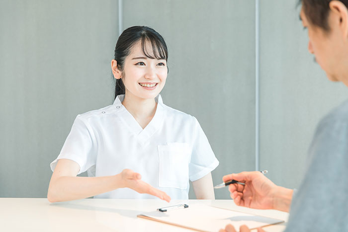 歯医者の受付での患者とのやり取りの様子