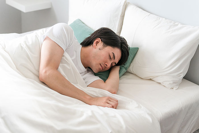ベッドで睡眠中の男性
